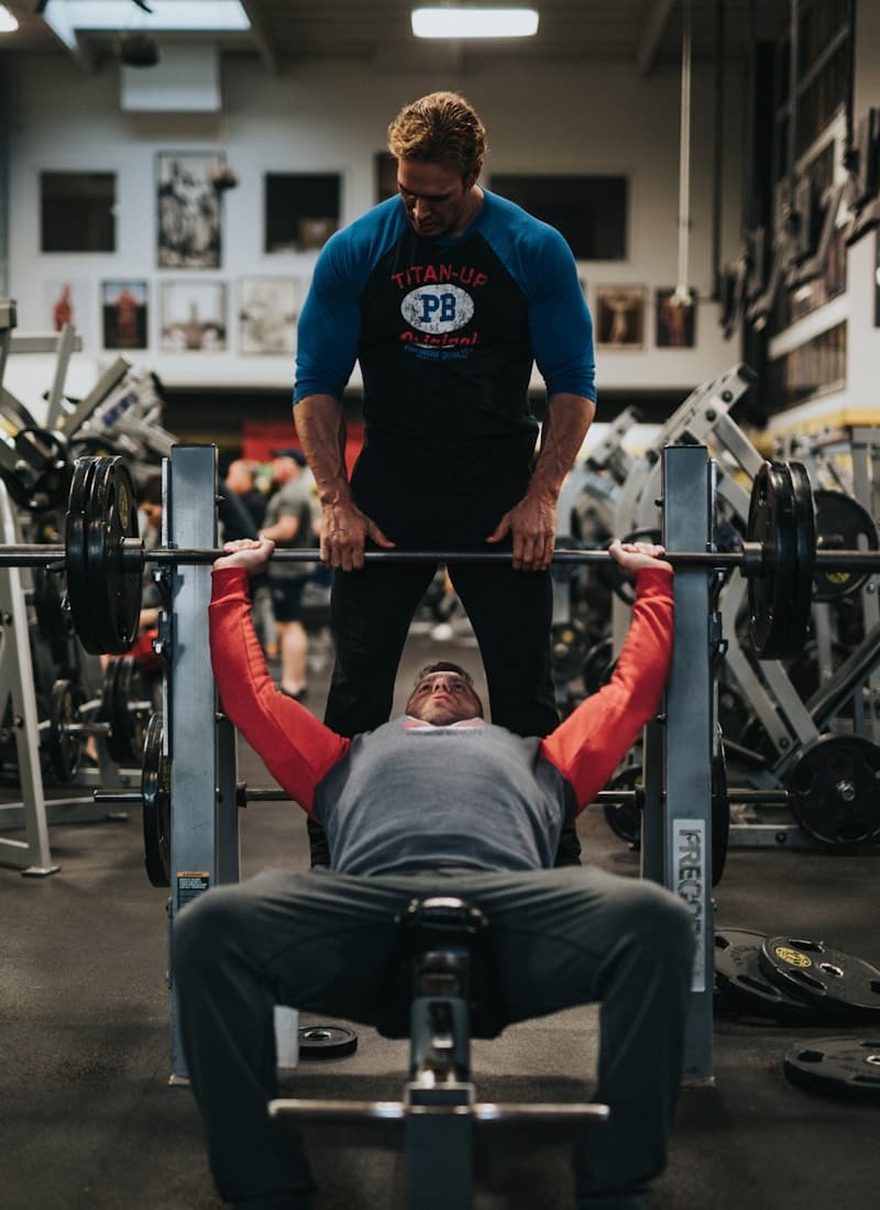 Personal training session — trainer spotting bench press